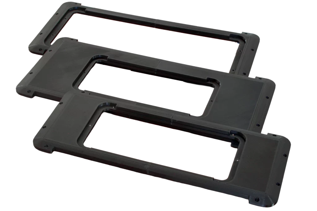 Drei schwarze, 3D-gedruckte Adapterplatten für Blackmagic ATEM Mini und ATEM Extreme Cases, versetzt übereinander liegend auf transparentem Hintergrund.